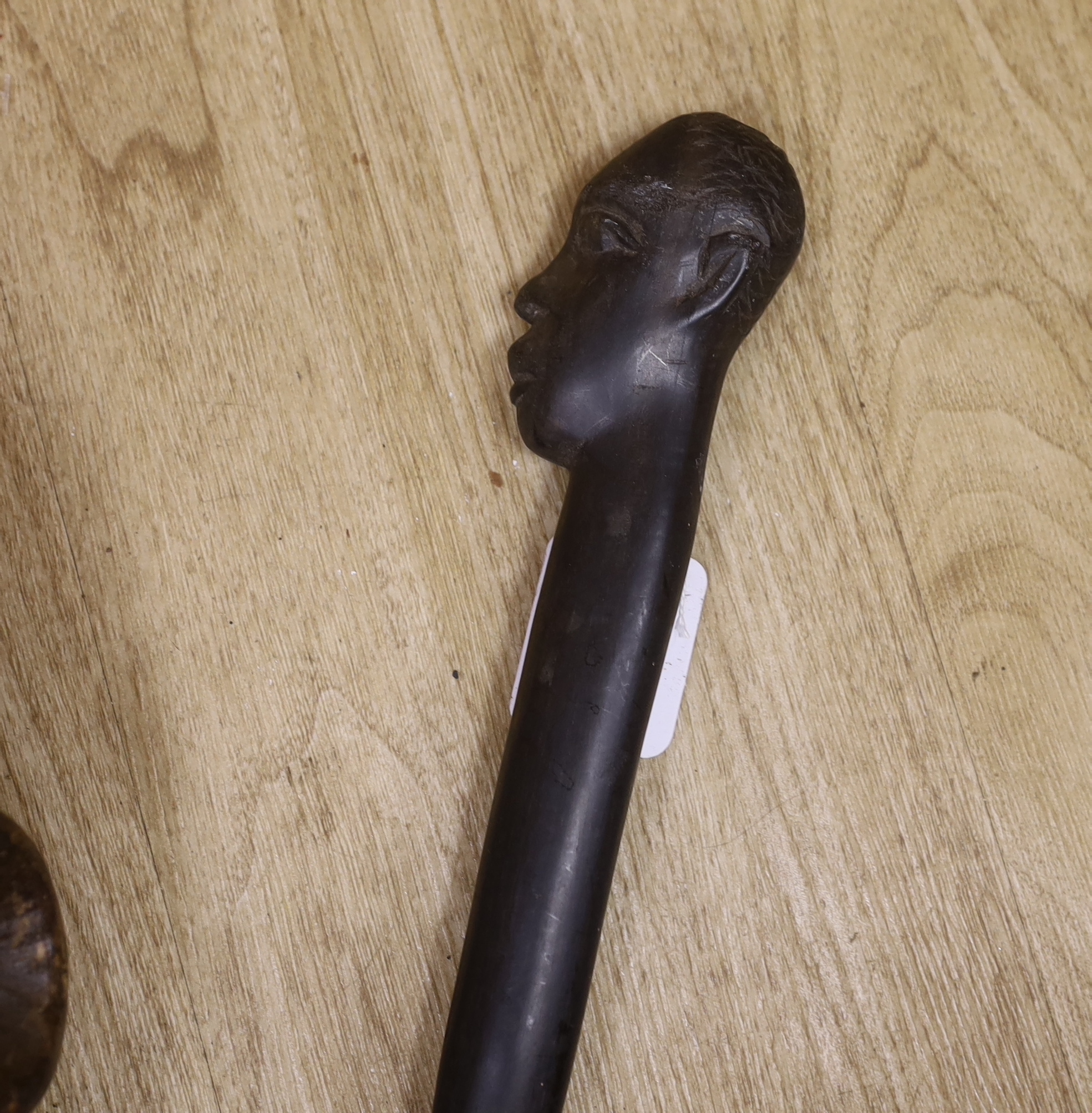 A tribal mask, a Knobkerrie and stick with carved head, stick 62.5cm